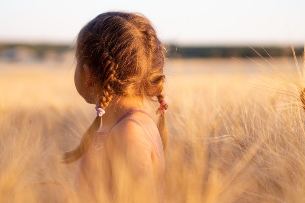 little girl with braided hair out in an open field, in representation of the article "When You Open Your Eyes You Realize How Shut They Were" by Comfortable Hell