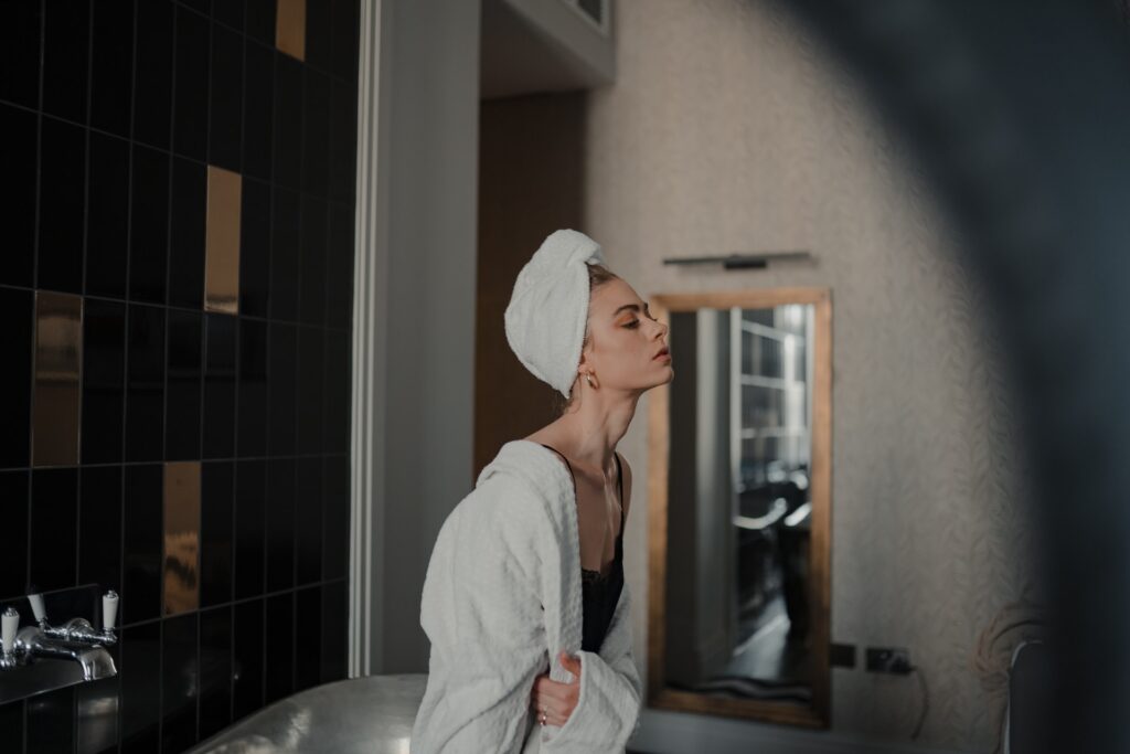 woman in the bathroom with white robe and white towel on her hair, representing the article "Hell Hath No Fury Like a Narcissist Denied" by Comfortable Hell